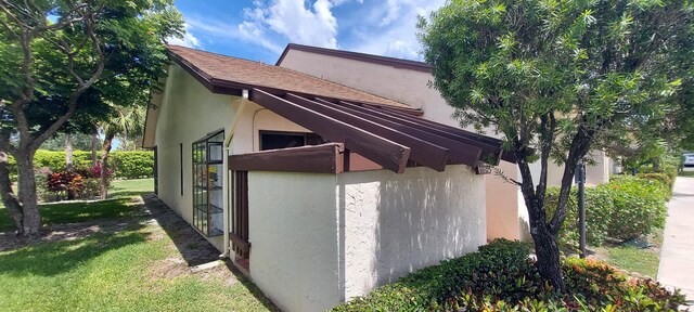 3710 English Rd Unit A, Lake Worth, FL 33467 - view of side of home with stucco siding and a lawn