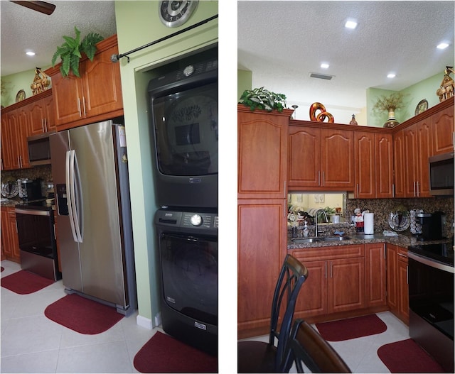 804 Sky Pine Way Unit C, Greenacres, FL 33415 - kitchen with appliances with stainless steel finishes, a sink, a textured ceiling, stacked washer / drying machine, and tasteful backsplash