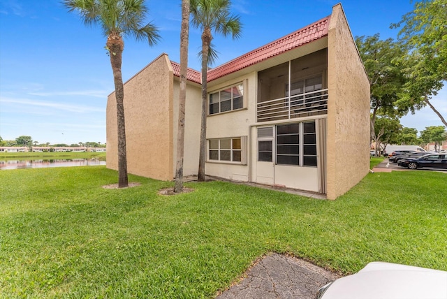 117 Lake Dora Dr, West Palm Beach, FL 33411 - back of property with stucco siding, a lawn, and a water view
