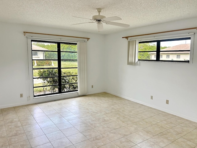 4940 Hawkwood Way Unit A, Boynton Beach, FL 33436 - tiled empty room featuring healthy amount of natural light, a ceiling fan, a textured ceiling, and baseboards