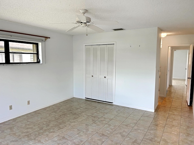 4940 Hawkwood Way Unit A, Boynton Beach, FL 33436 - unfurnished bedroom with a textured ceiling, a closet, a ceiling fan, and baseboards