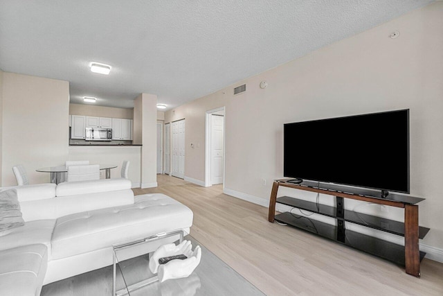 651 Okeechobee Blvd Unit 408, West Palm Beach, FL 33401 - living area with light wood-type flooring, baseboards, and a textured ceiling
