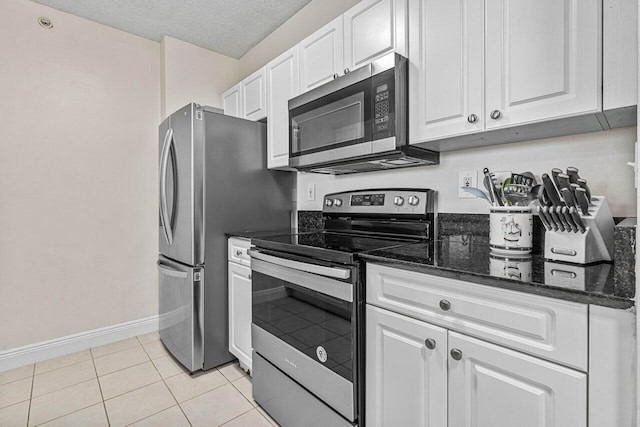 651 Okeechobee Blvd Unit 408, West Palm Beach, FL 33401 - kitchen featuring appliances with stainless steel finishes, white cabinetry, baseboards, dark stone counters, and a textured ceiling