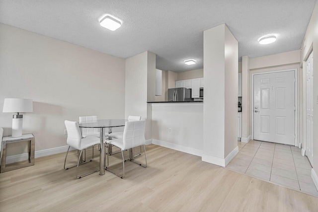 651 Okeechobee Blvd Unit 408, West Palm Beach, FL 33401 - dining area with light wood-type flooring, baseboards, and a textured ceiling