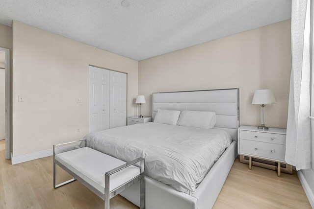 651 Okeechobee Blvd Unit 408, West Palm Beach, FL 33401 - bedroom with light wood finished floors, a textured ceiling, baseboards, and a closet