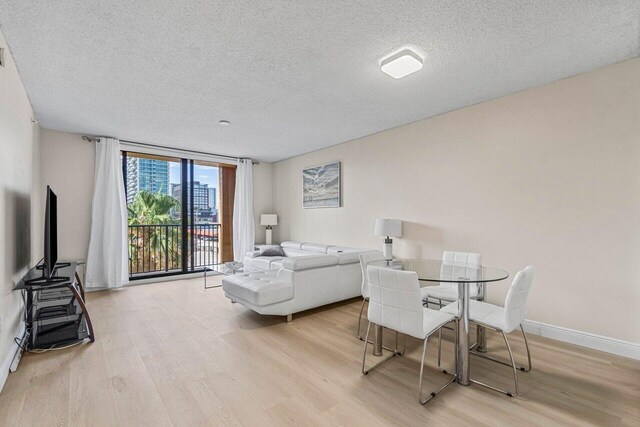 651 Okeechobee Blvd Unit 408, West Palm Beach, FL 33401 - bedroom featuring a textured ceiling, light wood-style flooring, and baseboards