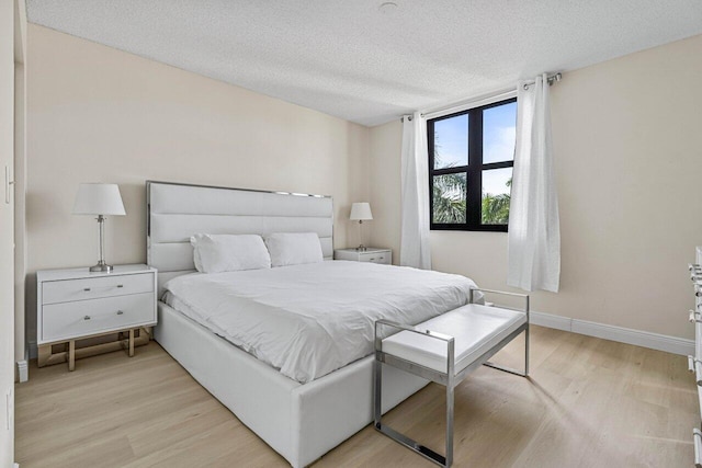 651 Okeechobee Blvd Unit 408, West Palm Beach, FL 33401 - bedroom with light wood-style flooring, baseboards, and a textured ceiling
