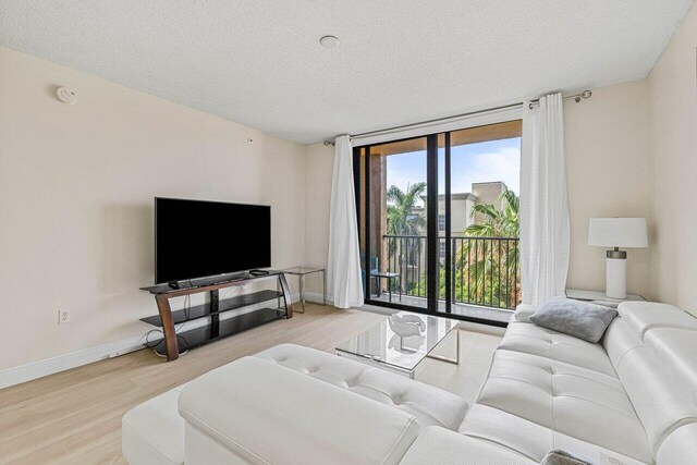 651 Okeechobee Blvd Unit 408, West Palm Beach, FL 33401 - living room featuring wood finished floors, a textured ceiling, and baseboards