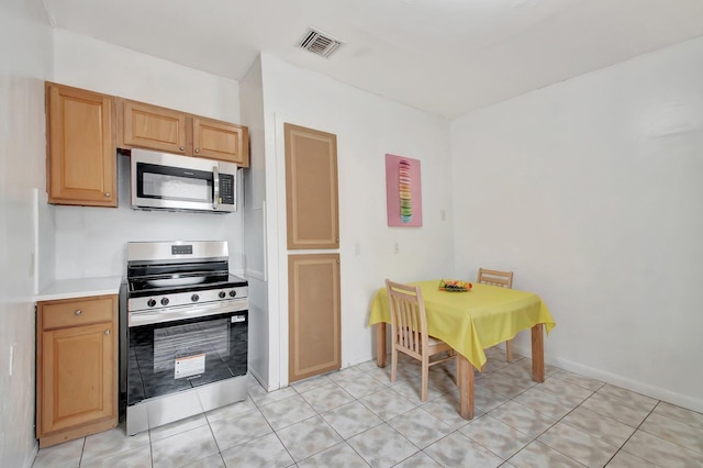 701 S J St, Lake Worth Beach, FL 33460 - kitchen with stainless steel appliances, light countertops, and light tile patterned floors