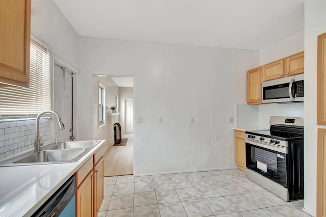 701 S J St, Lake Worth Beach, FL 33460 - kitchen featuring white microwave, stainless steel range with electric cooktop, a sink, light brown cabinetry, and healthy amount of natural light