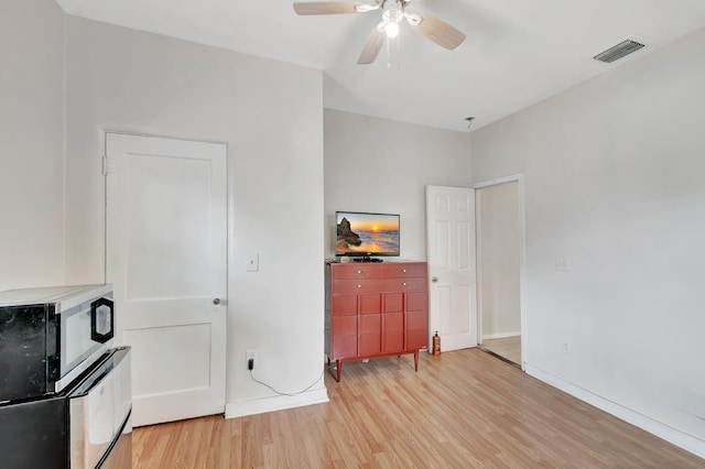 701 S J St, Lake Worth Beach, FL 33460 - unfurnished living room with light wood finished floors, ceiling fan, and baseboards