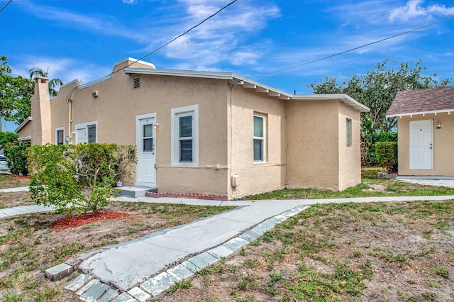 701 S J St, Lake Worth Beach, FL 33460 - view of home's exterior with stucco siding and a chimney