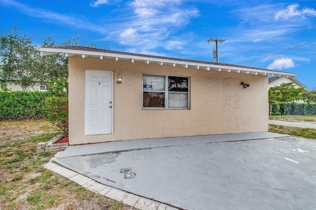 701 S J St, Lake Worth Beach, FL 33460 - back of property with stucco siding and a patio