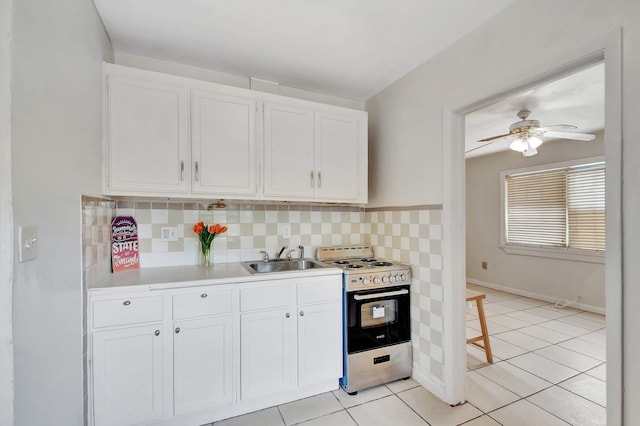 701 S J St, Lake Worth Beach, FL 33460 - kitchen featuring stove, a sink, light countertops, and white cabinetry