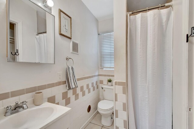 701 S J St, Lake Worth Beach, FL 33460 - bathroom featuring a sink, tile walls, toilet, tile patterned floors, and a wainscoted wall