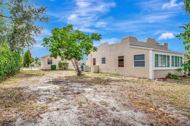 701 S J St, Lake Worth Beach, FL 33460 - back of house with stucco siding and central AC