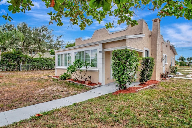701 S J St, Lake Worth Beach, FL 33460 - view of home's exterior featuring stucco siding and a chimney