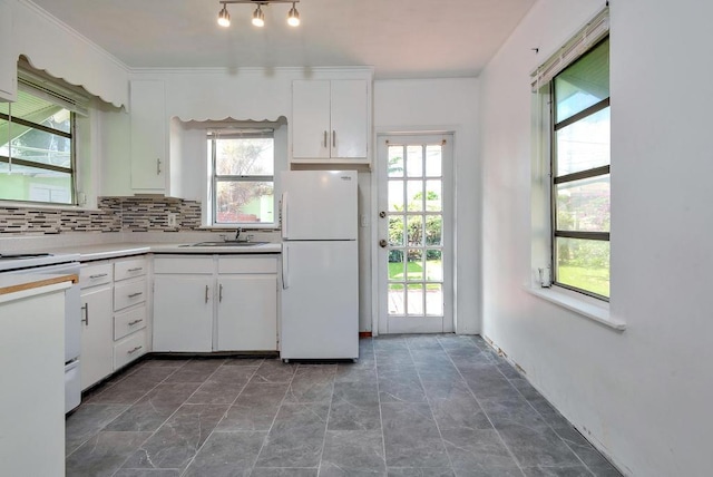 713 10th Ave N, Lake Worth Beach, FL 33460 - kitchen featuring white appliances, healthy amount of natural light, white cabinetry, and tasteful backsplash