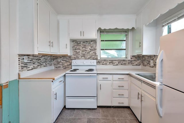 713 10th Ave N, Lake Worth Beach, FL 33460 - kitchen with white appliances, light countertops, white cabinets, backsplash, and crown molding