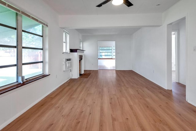 713 10th Ave N, Lake Worth Beach, FL 33460 - unfurnished living room featuring plenty of natural light, light wood-style flooring, a ceiling fan, heating unit, and beam ceiling
