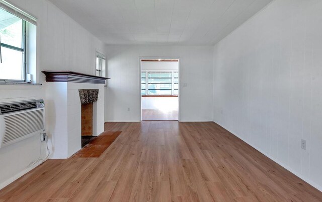 713 10th Ave N, Lake Worth Beach, FL 33460 - unfurnished living room featuring light wood finished floors and a tile fireplace