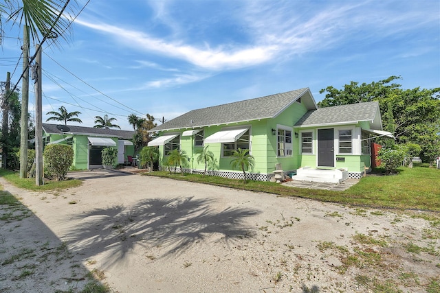 713 10th Ave N, Lake Worth Beach, FL 33460 - view of front facade with roof with shingles, dirt driveway, and entry steps