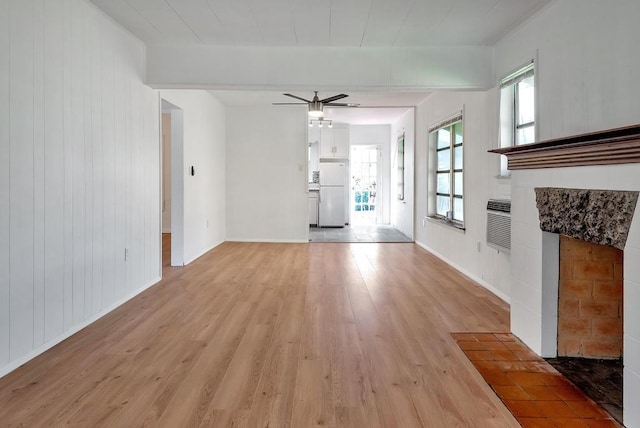 713 10th Ave N, Lake Worth Beach, FL 33460 - unfurnished living room with light wood-type flooring, a ceiling fan, baseboards, and wooden walls