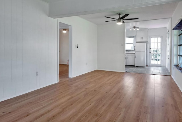 713 10th Ave N, Lake Worth Beach, FL 33460 - unfurnished living room featuring a ceiling fan, light wood-style flooring, and baseboards