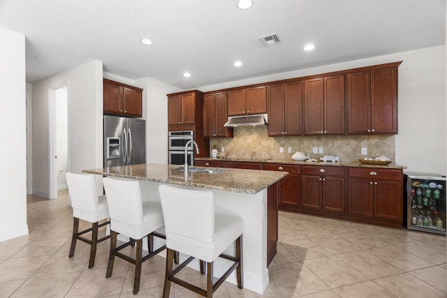2757 Wymberly Dr, Jupiter, FL 33458 - kitchen featuring appliances with stainless steel finishes, a sink, under cabinet range hood, wine cooler, and decorative backsplash