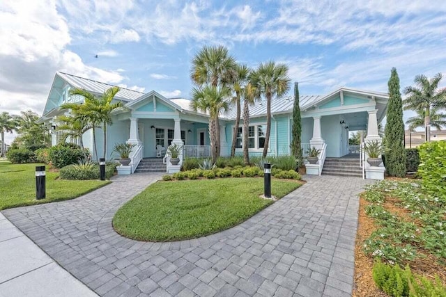 2757 Wymberly Dr, Jupiter, FL 33458 - view of front facade featuring a porch, decorative driveway, and a front lawn