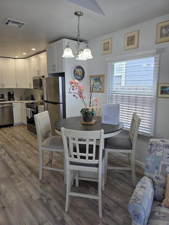 319 N J St, Lake Worth Beach, FL 33460 - dining space with a chandelier, wood finished floors, and recessed lighting