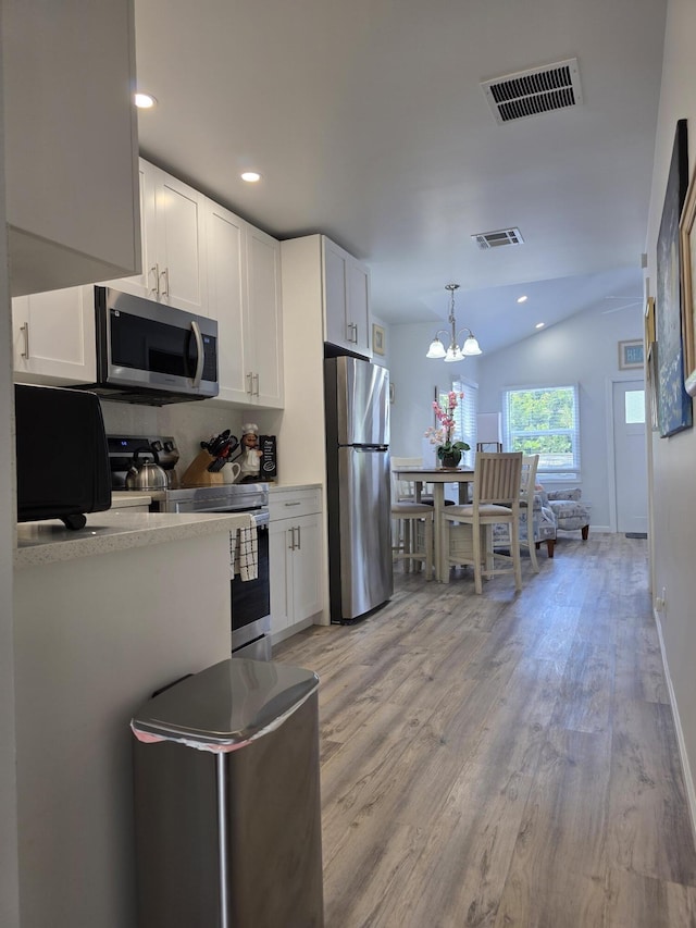 319 N J St, Lake Worth Beach, FL 33460 - kitchen with appliances with stainless steel finishes, a chandelier, white cabinets, light wood-style flooring, and recessed lighting
