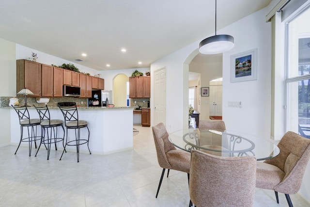 17560 72nd Rd N, The Acreage, FL 33470 - dining space featuring arched walkways, plenty of natural light, recessed lighting, and light tile patterned floors