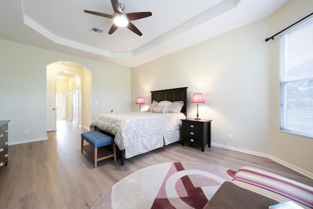 17560 72nd Rd N, The Acreage, FL 33470 - bedroom with a raised ceiling, arched walkways, light wood-style flooring, and baseboards