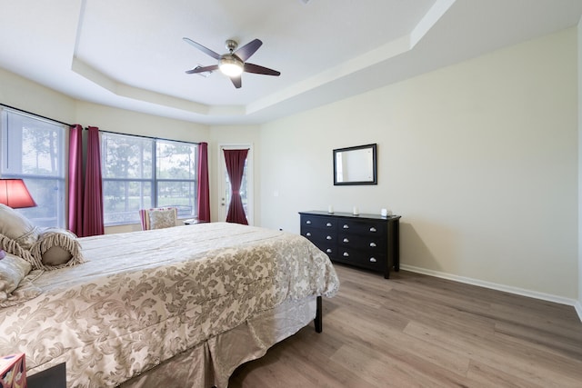 17560 72nd Rd N, The Acreage, FL 33470 - bedroom featuring a tray ceiling, light wood finished floors, baseboards, and a ceiling fan