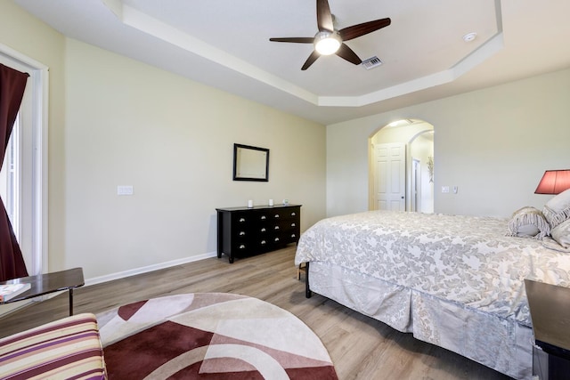 17560 72nd Rd N, The Acreage, FL 33470 - bedroom with arched walkways, a raised ceiling, wood finished floors, baseboards, and ceiling fan