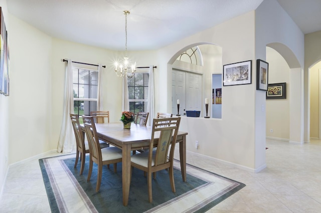 17560 72nd Rd N, The Acreage, FL 33470 - dining area with arched walkways, a chandelier, light tile patterned flooring, and baseboards