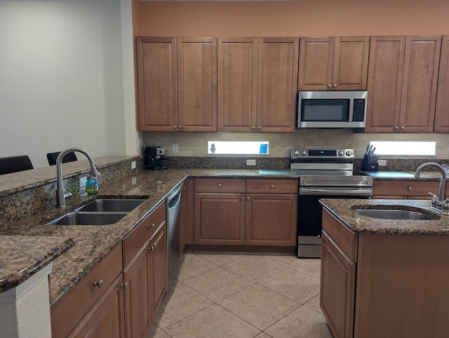 3104 SW Porpoise Cir, Stuart, FL 34997 - kitchen with stainless steel appliances, a sink, dark stone counters, and light tile patterned floors