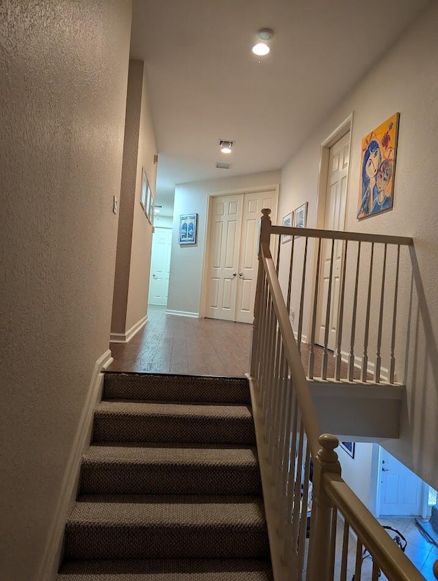 3104 SW Porpoise Cir, Stuart, FL 34997 - stairway featuring a textured wall, wood finished floors, baseboards, and recessed lighting