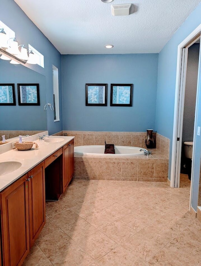 3104 SW Porpoise Cir, Stuart, FL 34997 - full bathroom with a garden tub, double vanity, toilet, a textured ceiling, and tile patterned flooring