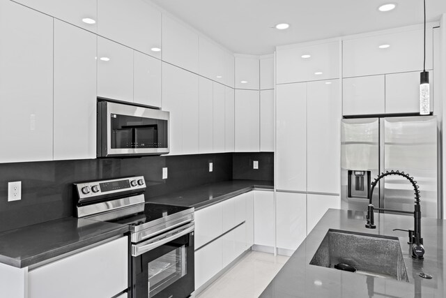 620 Raintree St E, Lehigh Acres, FL 33974 - kitchen with appliances with stainless steel finishes, a sink, modern cabinets, white cabinets, and tasteful backsplash