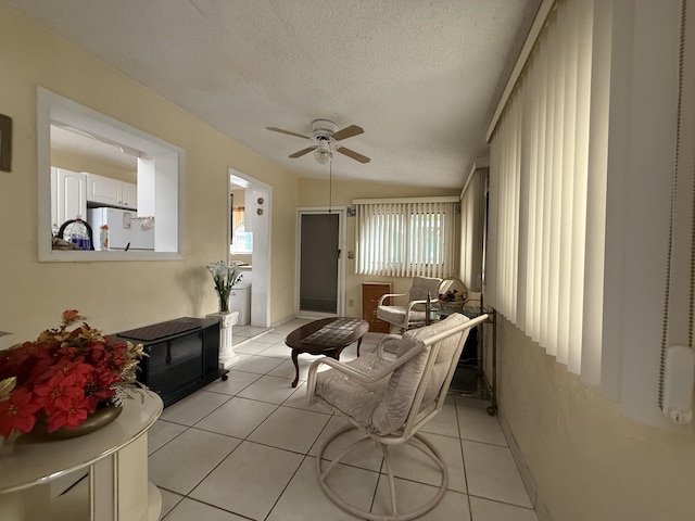 1810 Eucalyptus Ave, Fort Pierce, FL 34949 - living room featuring ceiling fan, a textured ceiling, light tile patterned floors, and baseboards