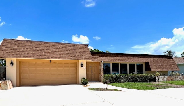 115 Sandpiper Ave, Royal Palm Beach, FL 33411 - view of front facade featuring mansard roof, roof with shingles, driveway, a garage, and stucco siding