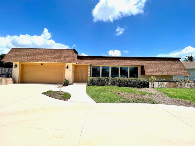 115 Sandpiper Ave, Royal Palm Beach, FL 33411 - front facade featuring mansard roof, a garage, roof with shingles, and concrete driveway