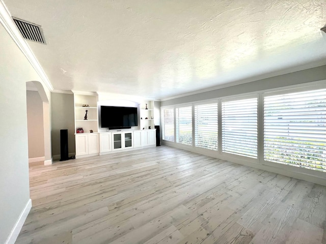 115 Sandpiper Ave, Royal Palm Beach, FL 33411 - unfurnished living room featuring crown molding, baseboards, arched walkways, light wood-style flooring, and a textured ceiling