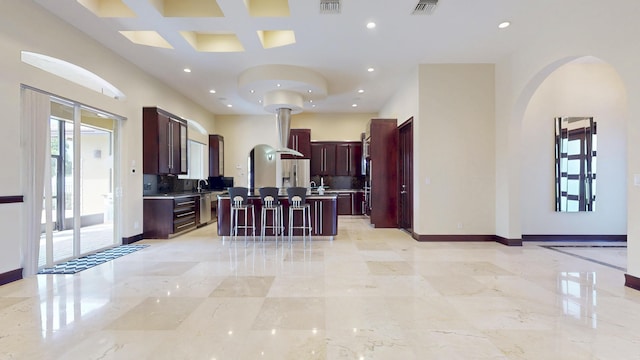 401 SE Verada Ave, Port Saint Lucie, FL 34983 - kitchen with stainless steel fridge, arched walkways, dark brown cabinets, open floor plan, and recessed lighting