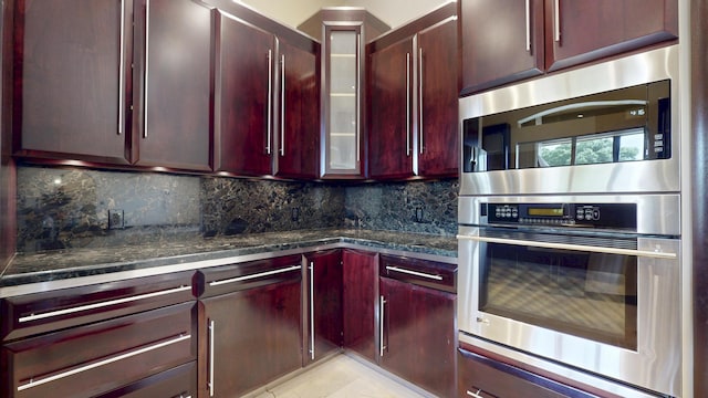 401 SE Verada Ave, Port Saint Lucie, FL 34983 - kitchen featuring reddish brown cabinets, appliances with stainless steel finishes, tasteful backsplash, and glass insert cabinets