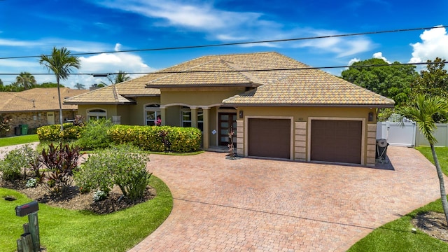 401 SE Verada Ave, Port Saint Lucie, FL 34983 - view of front of property featuring decorative driveway, a garage, a tile roof, and stucco siding