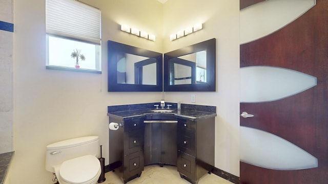 401 SE Verada Ave, Port Saint Lucie, FL 34983 - full bathroom with vanity, toilet, baseboards, and a tub to relax in