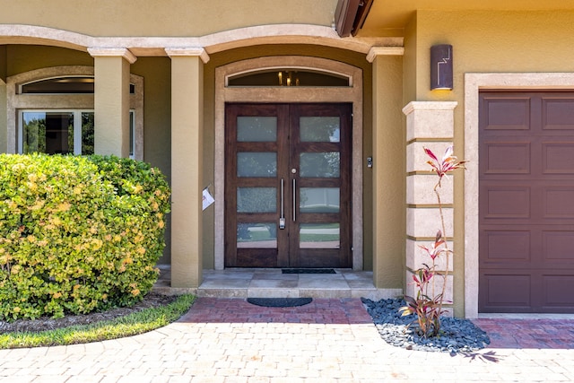 401 SE Verada Ave, Port Saint Lucie, FL 34983 - view of exterior entry featuring french doors, stucco siding, and a garage